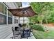 Cozy patio features a table and chairs under an umbrella next to the house and a yard at 178 Mission Oak Dr, Grayson, GA 30017