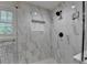 Glass shower featuring marble surround, black fixtures, and a tiled niche at 178 Mission Oak Dr, Grayson, GA 30017
