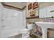 Bathroom with shower-tub, tile accents, pedestal sink and decorative details at 3133 Bridge Walk Dr, Lawrenceville, GA 30044