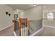 Hallway features neutral carpet, decorative railing, skylight, and arched window at 3133 Bridge Walk Dr, Lawrenceville, GA 30044