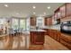 Modern kitchen with wooden cabinets, hardwood floors, eat-in dining, and stainless steel appliances at 3133 Bridge Walk Dr, Lawrenceville, GA 30044