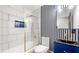 Modern bathroom with gold shower accents, blue vanity, and striped wall behind the toilet at 4158 Pepperdine Dr, Decatur, GA 30034