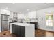 Well-lit kitchen featuring an island, stainless steel appliances, and sleek white cabinetry with modern hardware at 4158 Pepperdine Dr, Decatur, GA 30034