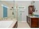 Well-lit bathroom featuring a glass shower, blue backsplash, and dark wood vanity with stone countertop at 725 Eider Down Ct, Alpharetta, GA 30022