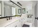 Bright bathroom with double sinks, a large mirror, and a striped shower curtain at 725 Eider Down Ct, Alpharetta, GA 30022