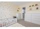 Bright bedroom with colorful polka dot wallpaper and built in dressers near a bathroom at 725 Eider Down Ct, Alpharetta, GA 30022