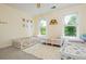 Charming bedroom with three twin beds, colorful decor, and two windows for natural light at 725 Eider Down Ct, Alpharetta, GA 30022