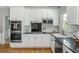 Bright kitchen features stainless steel appliances, white cabinets, and black countertops, creating a clean and modern feel at 725 Eider Down Ct, Alpharetta, GA 30022