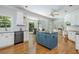 Open kitchen with a blue island, stainless steel appliances, and hardwood floors adjacent to a dining area at 725 Eider Down Ct, Alpharetta, GA 30022