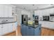 Well-lit kitchen with white cabinetry, blue island with black countertop, and stainless steel appliances, offering ample space at 725 Eider Down Ct, Alpharetta, GA 30022