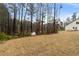 The house has white siding and the backyard has a large brown field at 8268 E Carroll Rd, Whitesburg, GA 30185