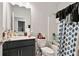 This bathroom features blue gray cabinets, a vanity, a mirror, a shower, and a toilet at 8268 E Carroll Rd, Whitesburg, GA 30185