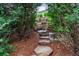 Stone steps meandering through the heavily wooded and landscaped backyard at 2490 Hillandale Cir, Cumming, GA 30041