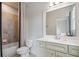 Well-lit bathroom featuring a toilet, vanity with cabinets, and a shower with a tiled enclosure at 2490 Hillandale Cir, Cumming, GA 30041