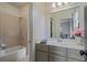 Bright bathroom featuring a tub with shower, vanity with storage, and natural light at 2490 Hillandale Cir, Cumming, GA 30041
