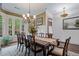 Formal dining room with hardwood floors, a chandelier, large windows, and views to the home's front yard at 2490 Hillandale Cir, Cumming, GA 30041