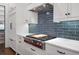 Gourmet kitchen with stainless steel range, blue tiled backsplash, and white countertops at 2490 Hillandale Cir, Cumming, GA 30041