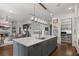 Well-appointed kitchen features an island with seating, open shelving, and modern fixtures at 2490 Hillandale Cir, Cumming, GA 30041