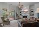 A living room boasting a stone fireplace, built-in shelves, a ceiling fan, large windows, and a comfortable leather sofa at 2490 Hillandale Cir, Cumming, GA 30041