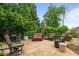 Stone patio with outdoor furniture, surrounded by lush landscaping and providing a relaxing outdoor space at 2490 Hillandale Cir, Cumming, GA 30041