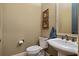 A half bathroom featuring a toilet, pedestal sink, a framed mirror, and neutral-toned walls at 2490 Hillandale Cir, Cumming, GA 30041
