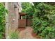 Side yard with a gravel path, a wooden gate, and mature trees, creating a private outdoor space at 2490 Hillandale Cir, Cumming, GA 30041