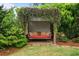 Inviting backyard porch swing with decorative pillows surrounded by lush greenery at 2490 Hillandale Cir, Cumming, GA 30041