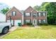 Traditional brick home with a lush green lawn, two-car garage, and driveway basketball hoop at 4041 Smithfield Trl, Ellenwood, GA 30294
