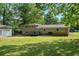 Large backyard featuring a brick house, a deck, a grill, and plenty of green space at 4070 Lauada Dr, Douglasville, GA 30135