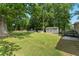 Expansive backyard featuring a storage shed, a trampoline, and a lush green lawn at 4070 Lauada Dr, Douglasville, GA 30135