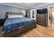 Bedroom with hardwood floors, a queen bed, and a large dresser with a TV mounted above at 4070 Lauada Dr, Douglasville, GA 30135