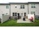 View of the backyard patio with furniture, lawn and two story siding of this townhome at 241 Irwell Path, Lawrenceville, GA 30044