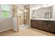 Bright bathroom featuring a glass shower stall, double vanity with cabinetry and a window at 241 Irwell Path, Lawrenceville, GA 30044