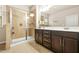 Bathroom featuring a glass shower stall, double vanity with cabinetry and a window at 241 Irwell Path, Lawrenceville, GA 30044
