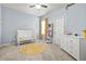 Bright bedroom with a crib, stylish rug, dresser, and natural light creating a warm and inviting atmosphere at 241 Irwell Path, Lawrenceville, GA 30044