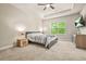 Large bedroom featuring a tray ceiling, ceiling fan, and view to the large window at 241 Irwell Path, Lawrenceville, GA 30044