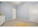 Neutral bedroom with a yellow rug, white dresser, and two entry doors for flexibility and privacy at 241 Irwell Path, Lawrenceville, GA 30044