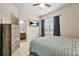 Cozy bedroom featuring a ceiling fan, TV, large window, and view to the en-suite bathroom at 241 Irwell Path, Lawrenceville, GA 30044