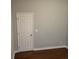 A cozy bedroom with a closed white door and dark hardwood floors at 490 Rockwell Sw St, Atlanta, GA 30310