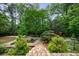 Lush backyard featuring landscaped gardens, pathways, and mature trees at 5120 Jett Forest Trl, Atlanta, GA 30327