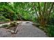 Lush backyard retreat featuring mature trees, stone pathways, and serene landscaping at 5120 Jett Forest Trl, Atlanta, GA 30327
