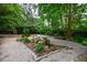 Tranquil backyard featuring lush greenery, a rock garden, and stone-paved pathways at 5120 Jett Forest Trl, Atlanta, GA 30327