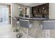 Elegant home bar featuring a granite countertop with seating and ample storage for entertaining at 5120 Jett Forest Trl, Atlanta, GA 30327