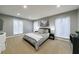 A well-lit, carpeted bedroom with a queen-sized bed, two windows, and modern decor at 5120 Jett Forest Trl, Atlanta, GA 30327