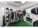 Functional walk-in closet with racks for storage, hanging space, and turf flooring for a unique aesthetic at 5120 Jett Forest Trl, Atlanta, GA 30327