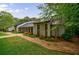 Beautiful one-story home with stone details, dark metal roof, surrounded by mature trees at 5120 Jett Forest Trl, Atlanta, GA 30327