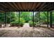 Outdoor brick patio with a spiral staircase and verdant greenery around the yard at 5120 Jett Forest Trl, Atlanta, GA 30327