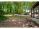 Large, tree-lined backyard offering privacy and a view of the sunroom at 157 Jousters Ln, Lawrenceville, GA 30044