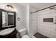 Bathroom featuring a stylish sink and a modern tile shower with a built in shelf at 157 Jousters Ln, Lawrenceville, GA 30044