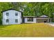 Inviting exterior view of a charming two-story home with manicured lawn and a convenient carport at 157 Jousters Ln, Lawrenceville, GA 30044